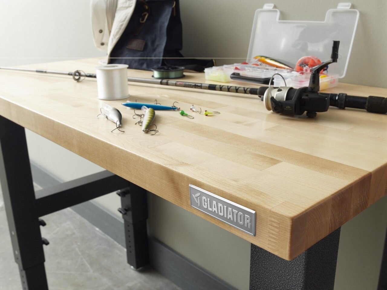 A Gladiator hardwood workbench against a garage wall with hand tools laid out on the top