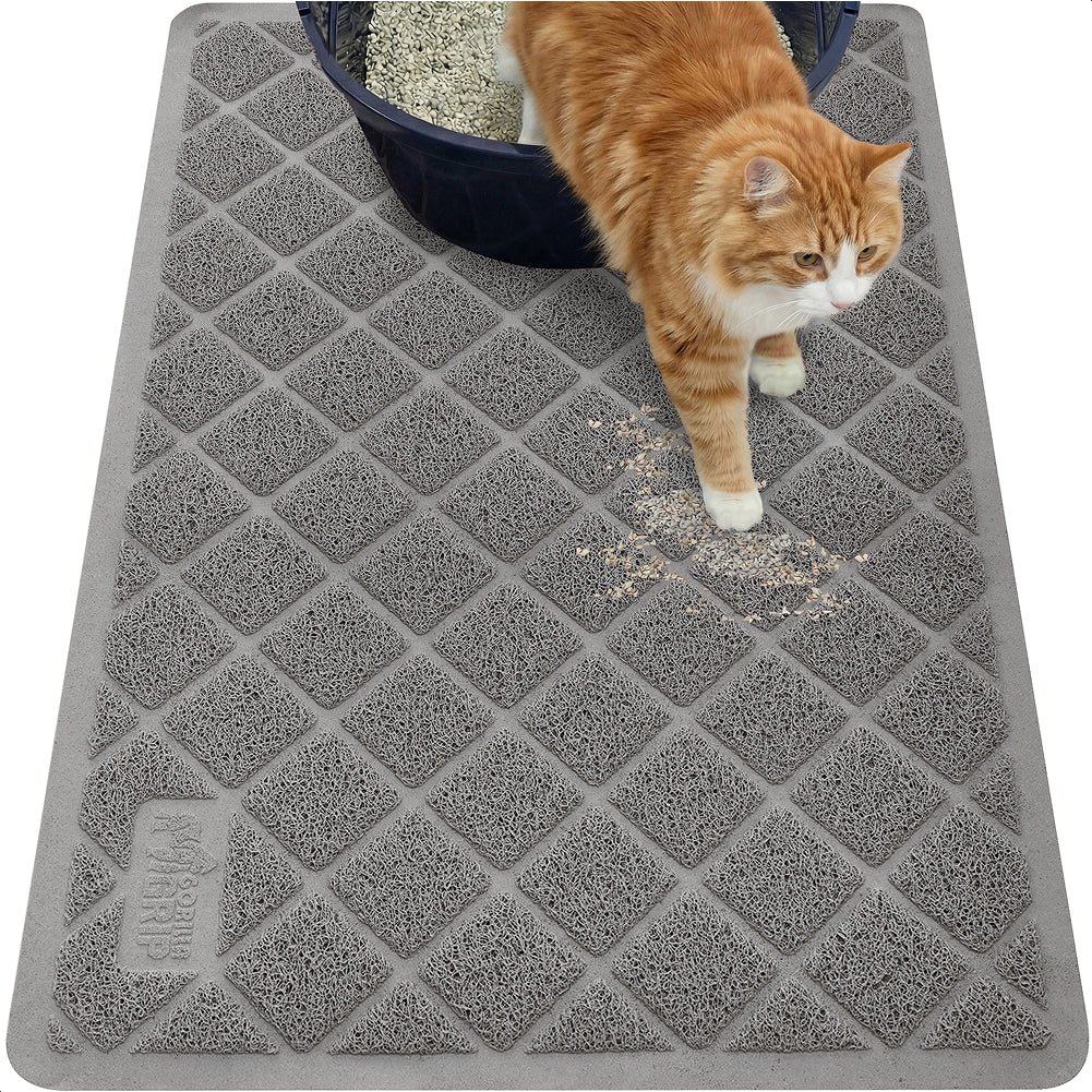 A ginger cat stepping off a grey litter mat that has caught the litter from its paws