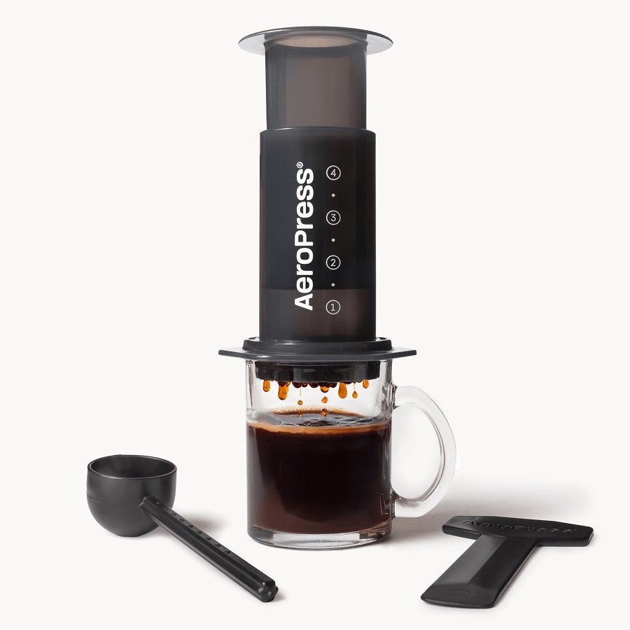 AeroPress Original coffee maker with its chamber, plunger, filter cap, stirrer and scoop laid out