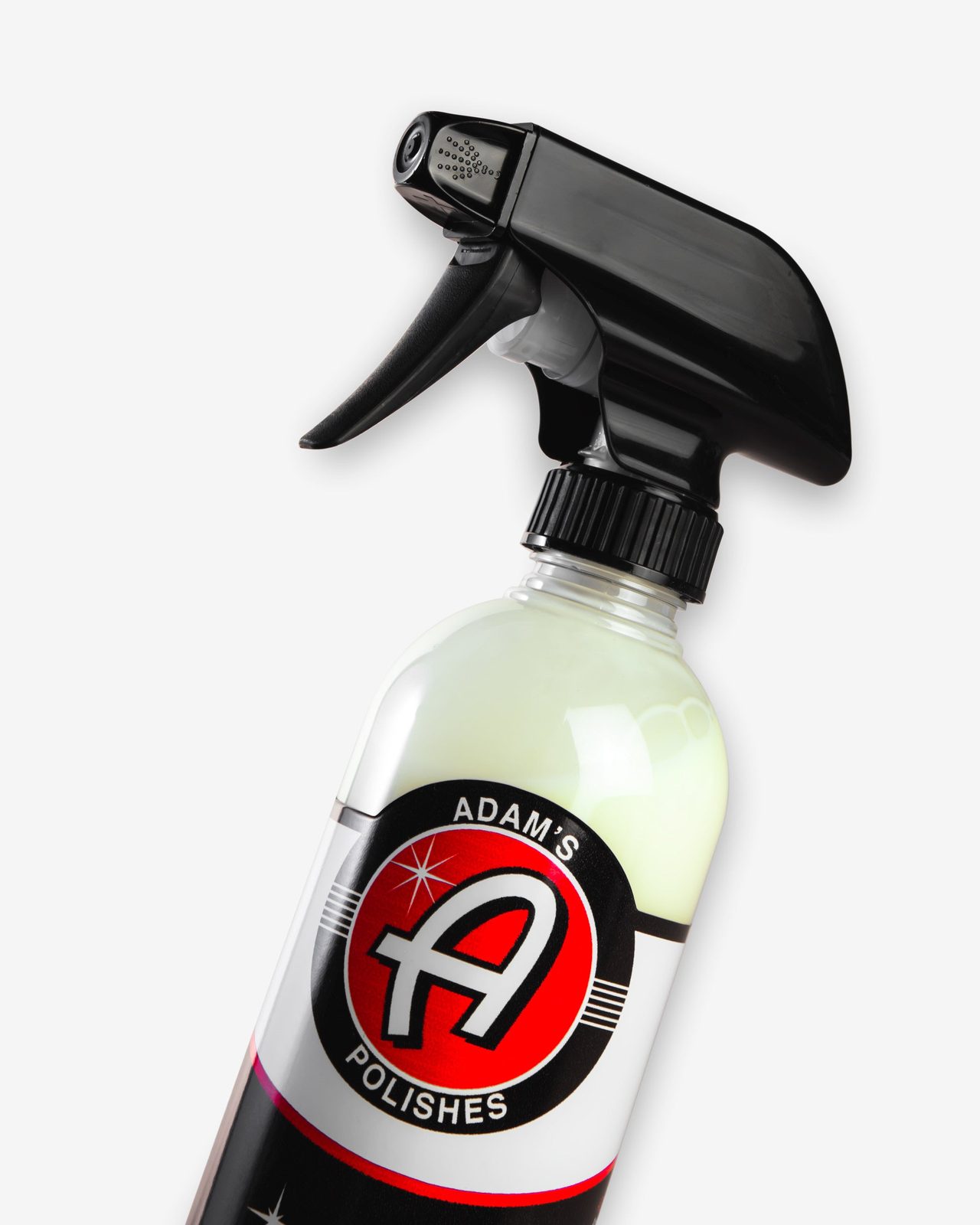 A trigger bottle of tire dressing photographed against a dark background